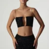 Ariana Oberteil mit Cut-outs und Verzierungen in Schwarz Ariana Oberteil mit Cut-outs und Verzierungen in Schwarz