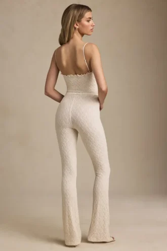 Arlena Jumpsuit mit Schleifenverzierung und ausgestellter Passform aus Spitze in Elfenbein