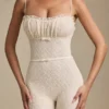 Arlena Jumpsuit mit Schleifenverzierung und ausgestellter Passform aus Spitze in Elfenbein