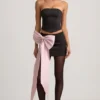 Carola Satin-Minirock mit Schleifendetail und niedriger Taille in Schwarz Carola Satin-Minirock mit Schleifendetail und niedriger Taille in Schwarz