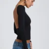 Elli Modal-Oberteil mit hohem Kragen, langen Ärmeln und offenem Rücken in Schwarz Elli Modal-Oberteil mit hohem Kragen, langen Ärmeln und offenem Rücken in Schwarz