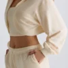 Gebürsteter Jersey-Cropped-Shrug mit Kapuze in Ecru Gebürsteter Jersey-Cropped-Shrug mit Kapuze in Ecru