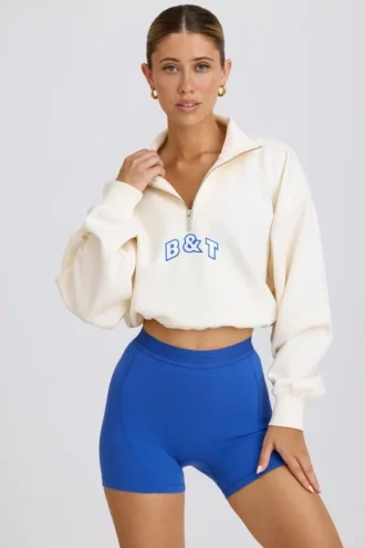 Kürzliches Sweatshirt mit Viertelreißverschluss in Weiß