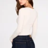 Luisa geripptes Modal-Oberteil mit Rüschen und langen Ärmeln in Elfenbein Luisa geripptes Modal-Oberteil mit Rüschen und langen Ärmeln in Elfenbein