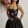 Nanala Neckholder-Minikleid mit Schnürung und Bubble-Saum in Schwarz mit Blumenprint