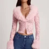 Noemy – Transparenter Cardigan aus Spitze mit Kunstfellbesatz in Rosa Noemy – Transparenter Cardigan aus Spitze mit Kunstfellbesatz in Rosa