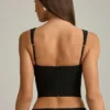 Pearla Korsett-Oberteil mit Cut-outs und Schleifendetail in Schwarz Pearla Korsett-Oberteil mit Cut-outs und Schleifendetail in Schwarz