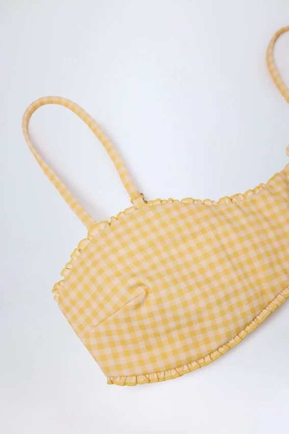 Portbou Bandeau-Bikinioberteil mit Rüschen in gelbem Gingham Portbou Bandeau-Bikinioberteil mit Rüschen in gelbem Gingham