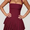 Rosaria Asymmetrisches, gestuftes Neckholder-Minikleid in Weinrot