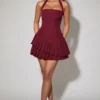 Rosaria Asymmetrisches, gestuftes Neckholder-Minikleid in Weinrot