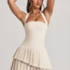 Rosaria Asymmetrisches, mehrlagiges Neckholder-Minikleid in Elfenbein
