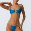 Sanibel Bikini-Oberteil mit Kettenverzierung und Cut-outs in Ozeanblau Sanibel Bikini-Oberteil mit Kettenverzierung und Cut-outs in Ozeanblau