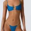 Sanibel Bikini-Oberteil mit Kettenverzierung und Cut-outs in Ozeanblau Sanibel Bikini-Oberteil mit Kettenverzierung und Cut-outs in Ozeanblau