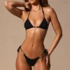 Serina String-Bikinihose mit seitlichen Bändern in Schwarz Serina String-Bikinihose mit seitlichen Bändern in Schwarz