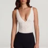 Zayla Transparenter Spitzen-Bodys mit Wellenrand und tiefem Ausschnitt in Weiß Zayla Transparenter Spitzen-Bodys mit Wellenrand und tiefem Ausschnitt in Weiß